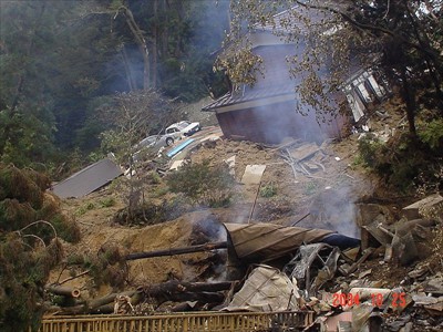 Surfacial landslide mass have carried some houses down. Photo by K. Konagai at 37.365531, 138.87782, Oct. 25th 2004